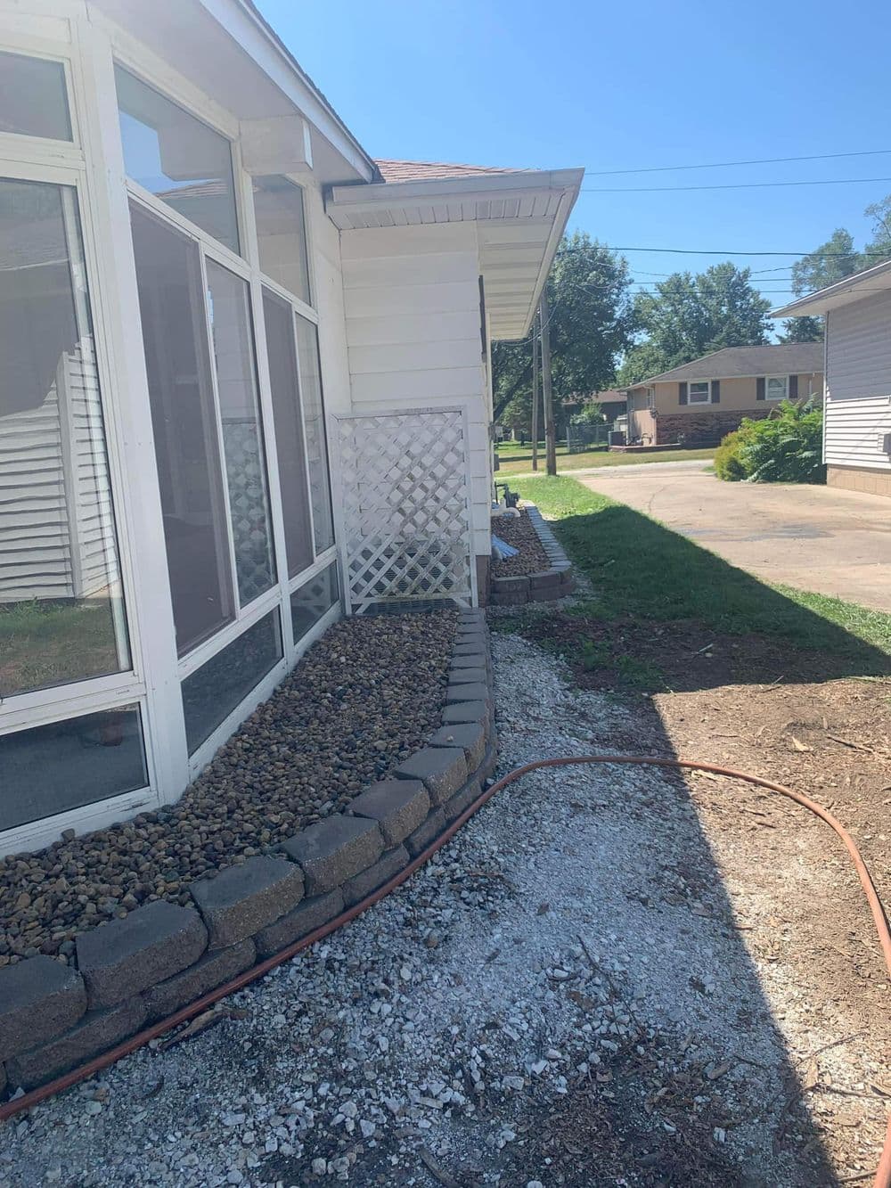 Side view of a house with gravel landscaping and decorative stone border.